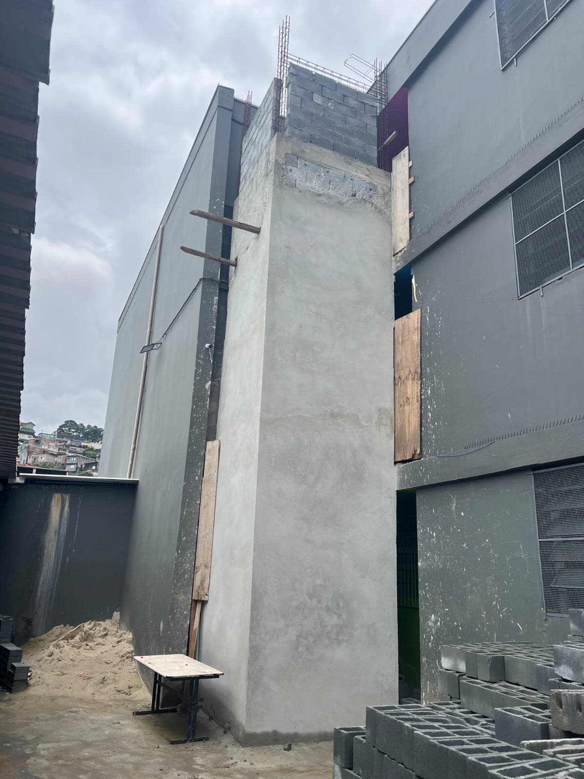 Vista externa da torre de elevador pronta e passarelas de acesso instaladas, resolvendo os problemas de acessibilidade entre os prédios da escola.